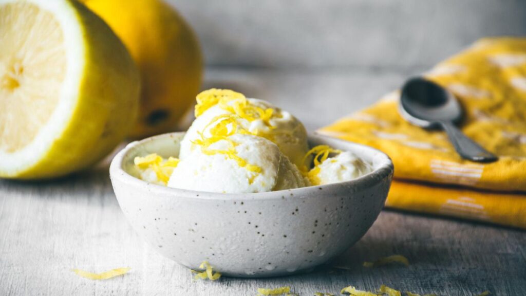 No churn lemon ice cream in a bowl with fresh lemons