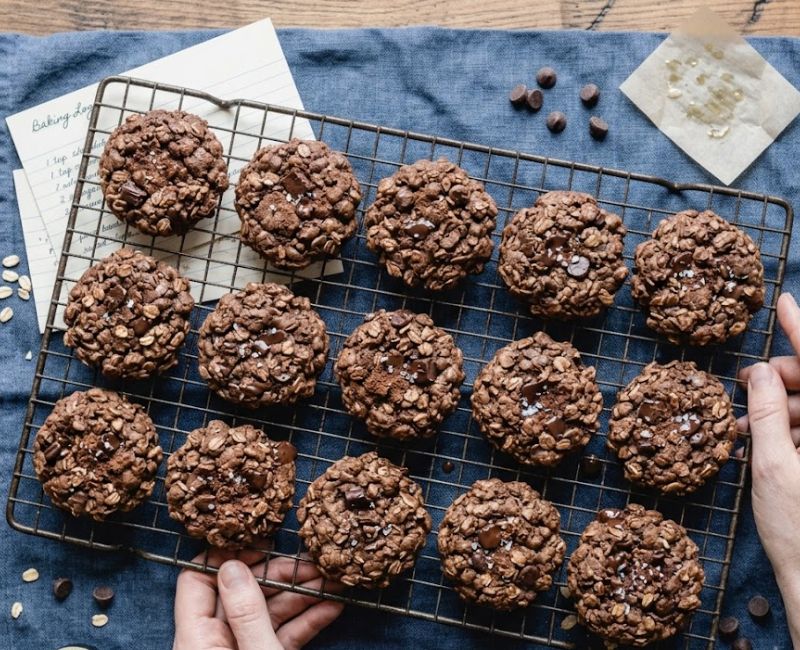 Freshly baked oats cocoa cookies cooling on a wire rack