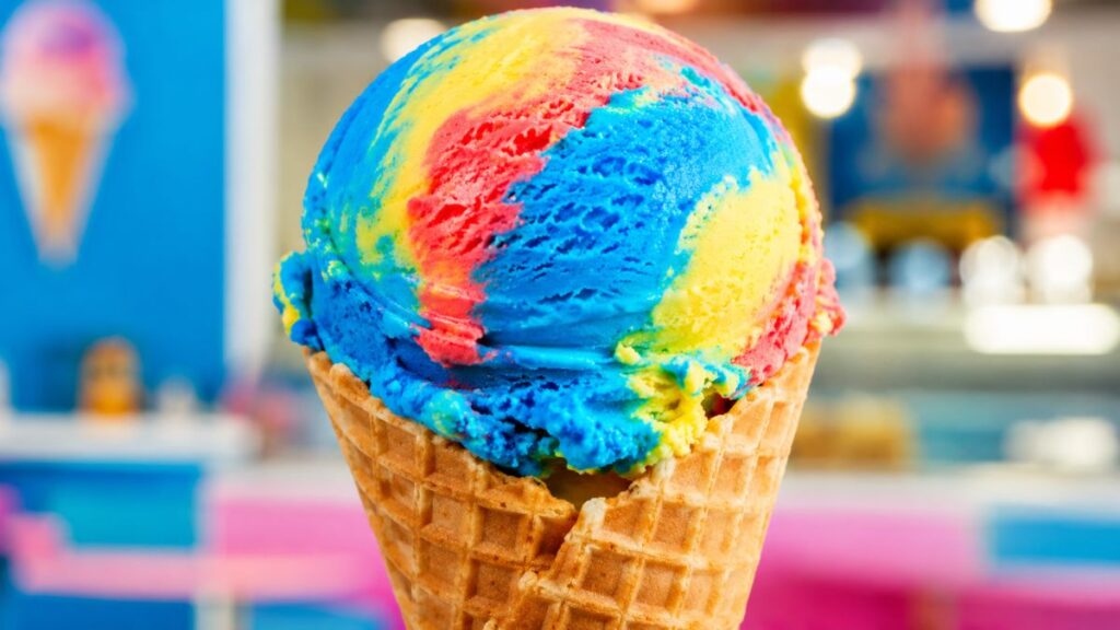 Superman ice cream with colorful blue, red, and yellow swirls in a waffle cone