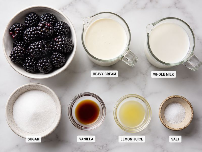 Ingredients for homemade blackberry ice cream arranged on a kitchen counter