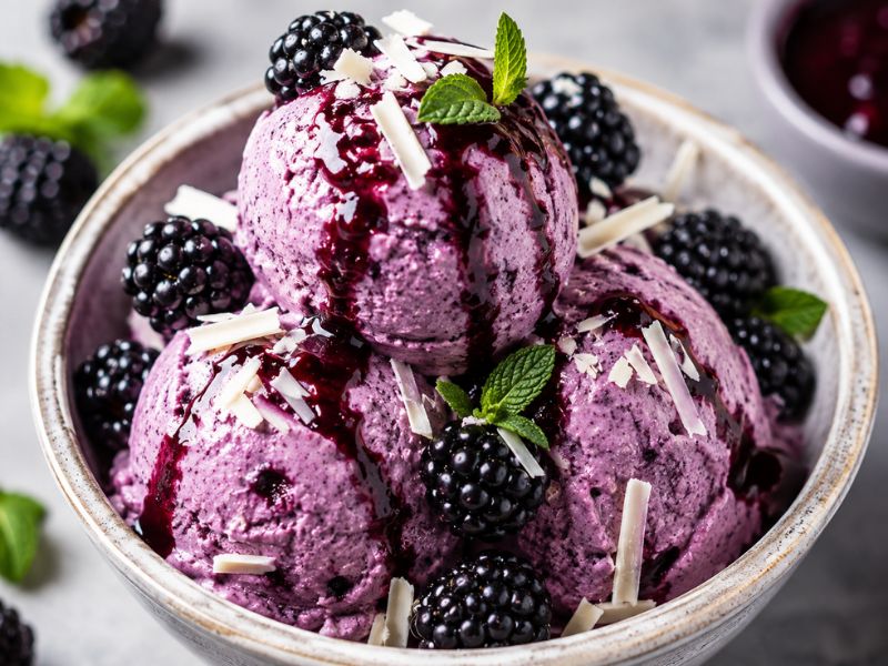 Blackberry ice cream served with fresh berries and blackberry sauce