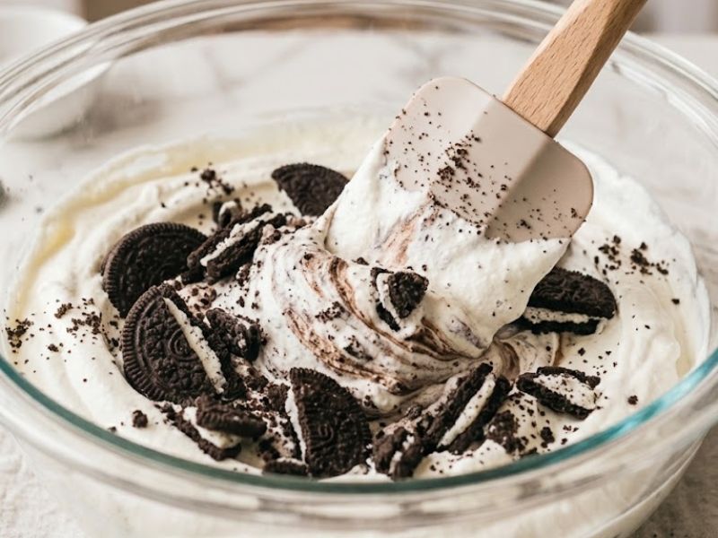 folding crushed Oreo cookies into homemade ice cream
