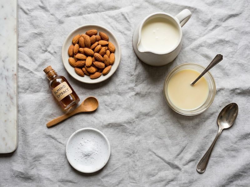 Ingredients for homemade almond ice cream including cream, condensed milk and roasted almonds