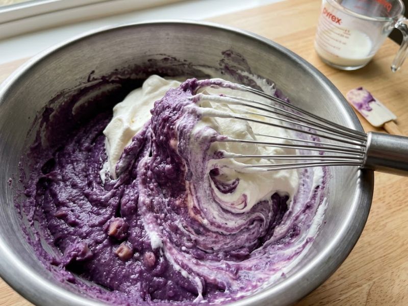 Mixing ube ice cream base with whipped cream