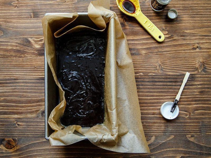 Transferring freshly churned black licorice ice cream to a freezer container