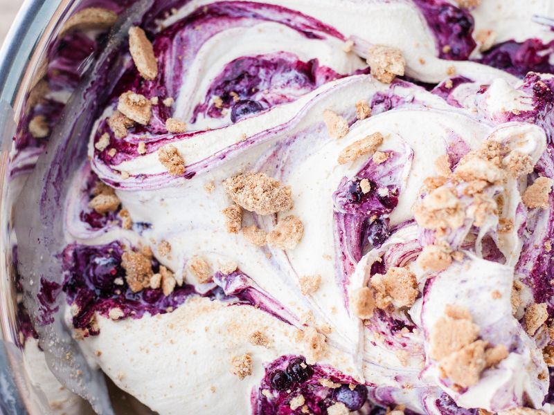 Distinct blueberry ribbons and graham cracker pieces in cheesecake ice cream