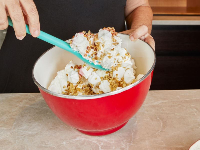 Folding bacon and toffee pieces into the maple ice cream mixture